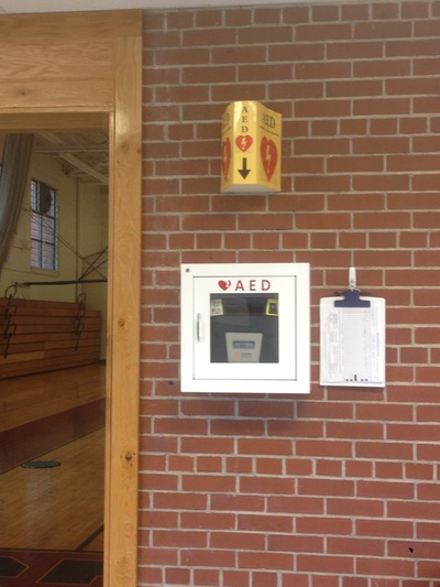 AED mounted on wall outside entrance to home side of Swain Middle School gym